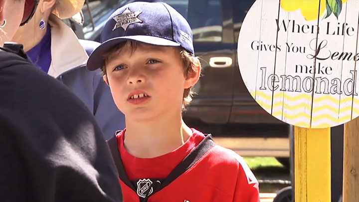 Tate Barton, 9, completes another sale at his lemonade stand on the Little Britches Rodeo parade route in High River. His business has raised tens of thousands of dollars for cancer care in his town.