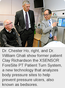 Dr. Chester Ho, right, and Dr. William Ghali show former patient Clay Richardson the XSENSOR ForeSite PT Patient Turn System, a new technology that analyzes body pressure sites to help prevent pressure ulcers, also known as bedsores.