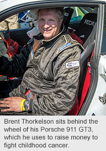 Brent Thorkelson sits behind the wheel of his Porsche 911 GT3, which he uses to raise money to fight childhood cancer.