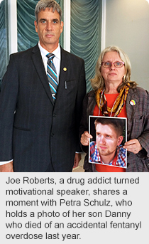 Joe Roberts, a drug addict turned motivational speaker, shares a moment with Petra Schulz, who holds a photo of her son Danny who died of an accidental fentanyl overdose last year.