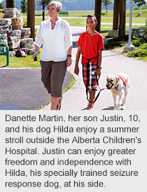 Danette Martin, her son Justin, 10, and his dog Hilda enjoy a summer stroll outside the Alberta Children's Hospital. Justin can enjoy greater freedom and independence with Hilda, his specially trained seizure response dog, at his side.
