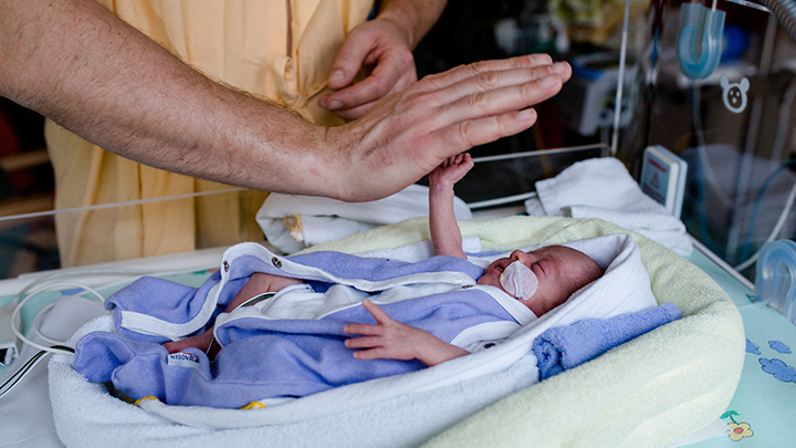 NICU baby high fives adult