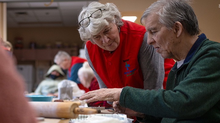AHS Volunteer Truusje Gensis helps Crowsnest Pass Health Centre long term care resident, Doug Calliou, as he works on a clay owl during 'Clay with Cori'.