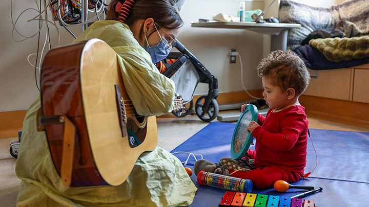 A music therapist at Alberta Children's Hospital plays a healing tune for Colby.