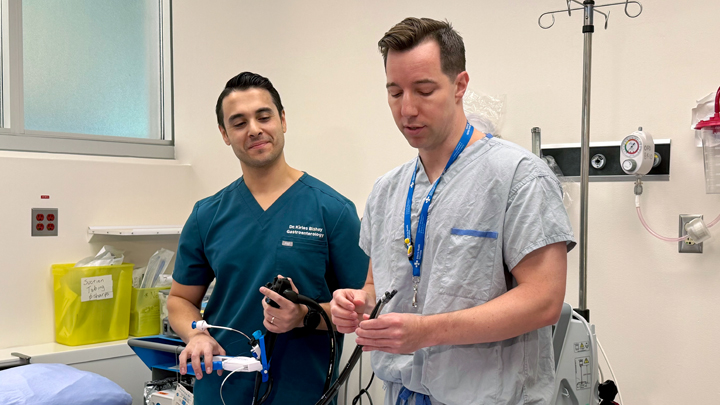 Dr. Bishay and Dr. Noah Switzer demonstrate how they insert a thin flexible tube with a camera down the mouth and into the stomach. Photo by Evan Isbister.
