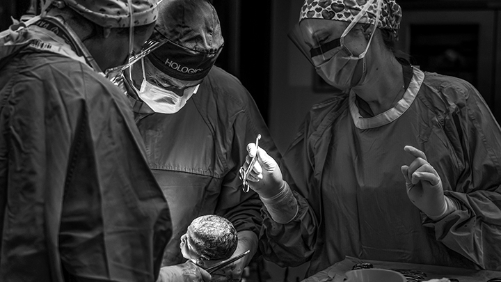 As a baby is delivered in the OR, the team prepares to begin neonatal stabilization.