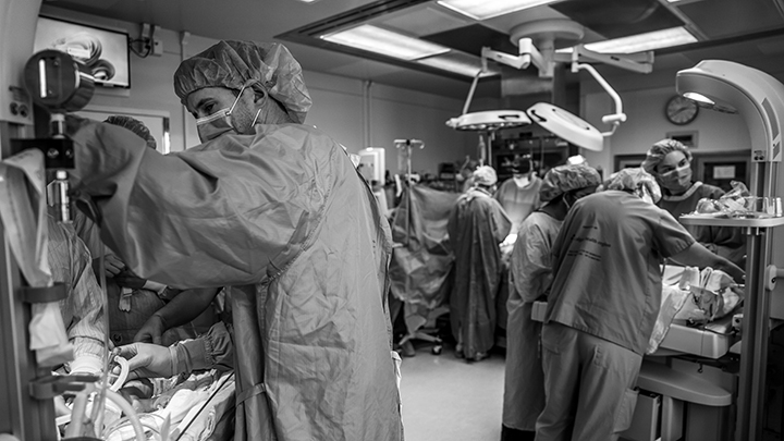 As a surgical team cares for their mother in the centre of the room, two neonatal teams work simultaneously to stabilize the newborn twins.