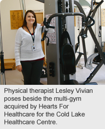 Physical therapist Lesley Vivian poses beside the multi-gym acquired by Hearts For Healthcare for the Cold Lake Healthcare Centre