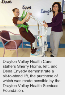 Drayton Valley Health Care staffers Sherry Horne, left, and Dena Enyedy demonstrate a sit-to-stand lift, the purchase of which was made possible by the Drayton Valley Health Services Foundation.