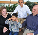 David Minchin places a stethoscope on a model of a heart as pediatric cardiologist Dr. Yashu Coe looks on