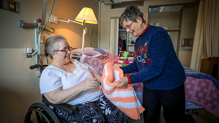 Vicki Shultz, left, was delighted to receive a quilt from Pat Grenier. Shultz and 29 other residents in long-term care at the Innisfail Health Centre received the homemade quilts as Christmas gifts thanks to the sewing talent and generosity of Grenier. Photo by Leah Hennel