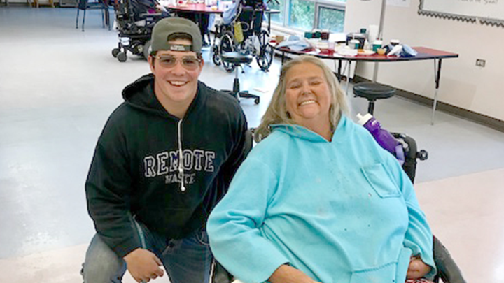 Tristan Anderson shares a smile with Fairview Health Complex resident Tana Koliebaba. Anderson participated in the Rupertsland Summer Student Employment Program.