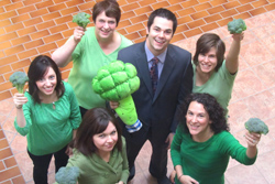 People wearing green, holding up broccoli
