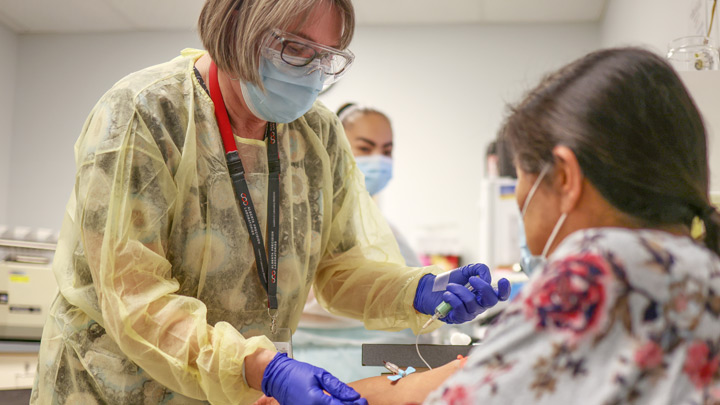Denice Dery, a medical lab assistant with Alberta Precision Laboratories, performs a blood collection on a patient at Stoney Health Services in Morley.