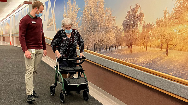 healthcare worker helping woman with walker