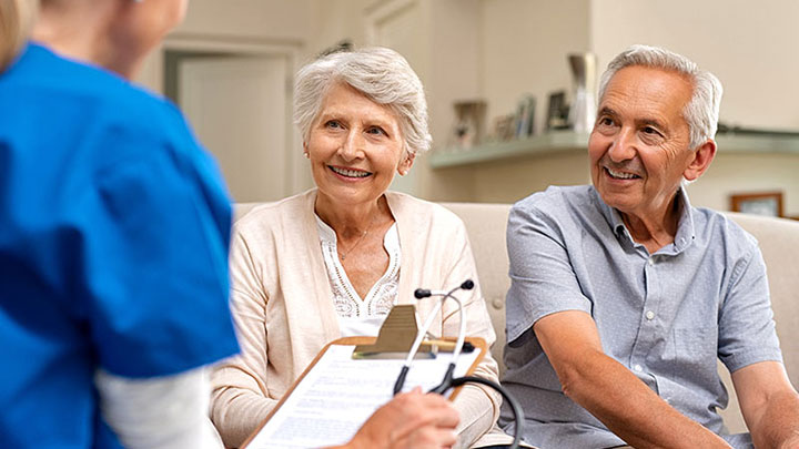 healthcare provider talking with older couple