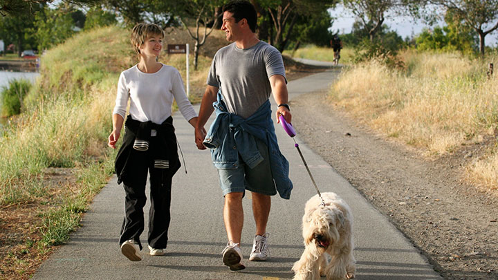 husband and wife walking dog