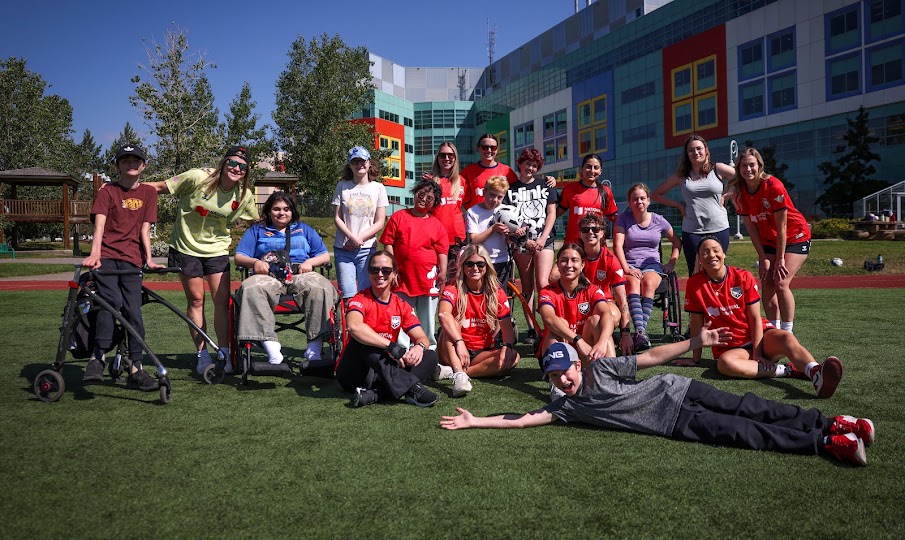 Calgary Wild FC players visit with young patients, sharing soccer skills, smiles and time together during the hospital's summer camp program.