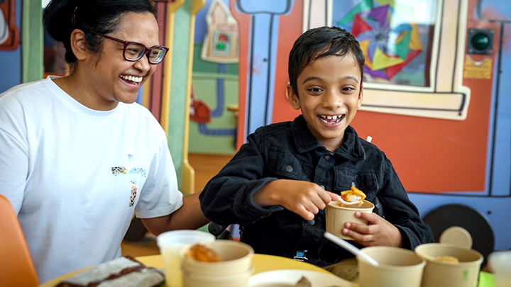 Seven-year-old Emmanuel enjoys his favourite menu item, butter chicken, with his mom during the launch of the new pediatric menu and room service model at Alberta Children's Hospital.
