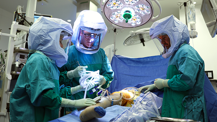 The surgical team examines an image of the artificial hip of Boyd English, who underwent a procedure that introduced bacteriophages to the infected area, followed by twice-daily intravenous phage infusions for 14 days.
