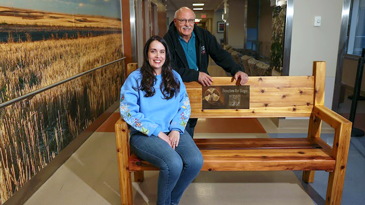 Melissa Lundy, left, founder and president of the Tipi of Hope Foundation, shares a moment with artisan Alfred Dumont, who crafted the bench.