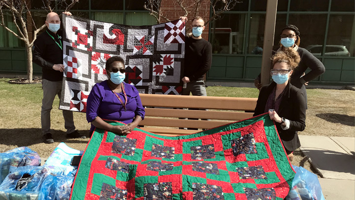 Members of the Mental Health team at Peter Lougheed Centre display a few of the quilts donated to Calgary Zone patients by the Blankets of Love Mental Health Foundation.