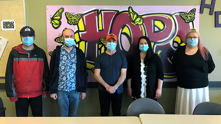 Peer-support worker Yvonne Benson, second from right, poses with program participants at the Carnat Centre in Calgary.