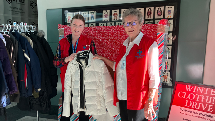Alberta Health Services volunteers Brooklyn Slingerland, left, and Marg Keeling hang coats donated to the Chinook Regional Hospital winter clothing drive.