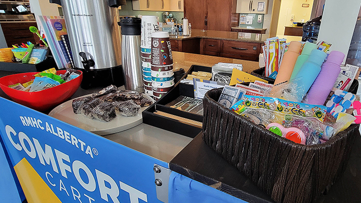 Along with bottled water and juices, granola bars and other snacks, the Comfort Cart provides tissues, reading material, activity books and hygiene items like toothbrushes. Volunteers from Ronald McDonald House circulate with the cart to the various units, offering items to families.