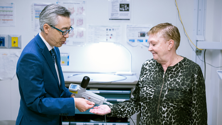 Dr. Clarence Wong, a gastroenterologist at the Royal Alexandra Hospital, shows Paulette Barry the balloon that was used through an endoscope to deliver liquid nitrogen to precancerous cells inside her esophagus.