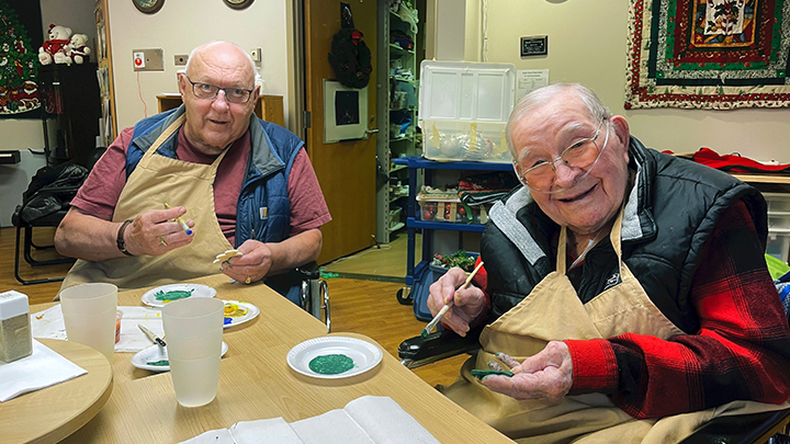 Roy Hale, left, and Peter Barnay paint salt-dough ornaments as part of the holiday celebrations held for long term care residents at the Devon General Hospital.