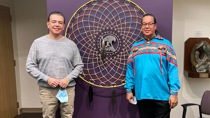 Warren Michael, left, Indigenous coordinator for Cancer Care, and artist Richard Nookohoo of Chipewyan Prairie First Nation pose with the dreamcatcher Nookohoo created for the Cross Cancer Institute.