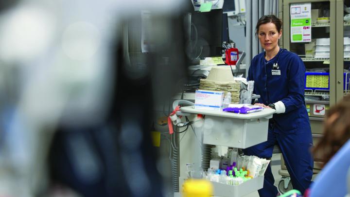 Nielsen speaks with a patient while charting on a roving computer. She assesses them and, using protocols she orders labs based on their symptoms. By the time the physician arrives, some results are already in. The autonomy of ED nursing drew her to the role — working independently but always as part of a team with a shared goal: getting patients the care they need.