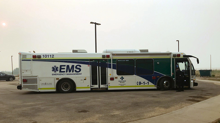 An EMS patient transport bus prepared to evacuate patients and continuing care residents from a smoky Valleyview.