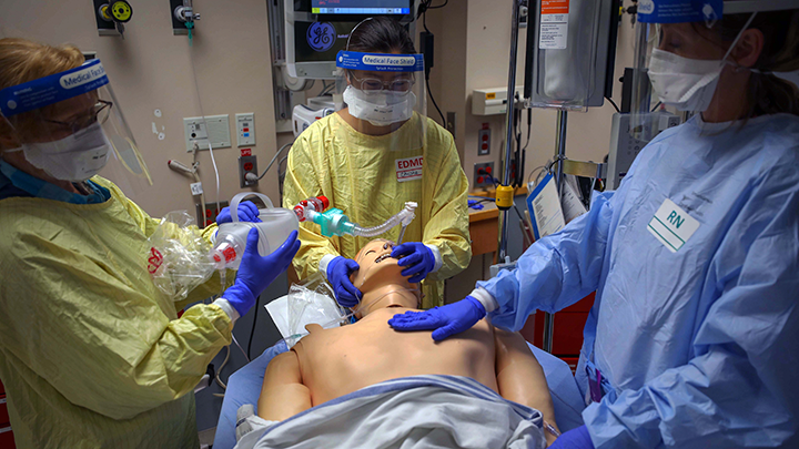 Members of the eSIM provincial team participate in a COVID-19 simulation exercise on a mannequin patient at Foothills Medical Centre in Calgary.