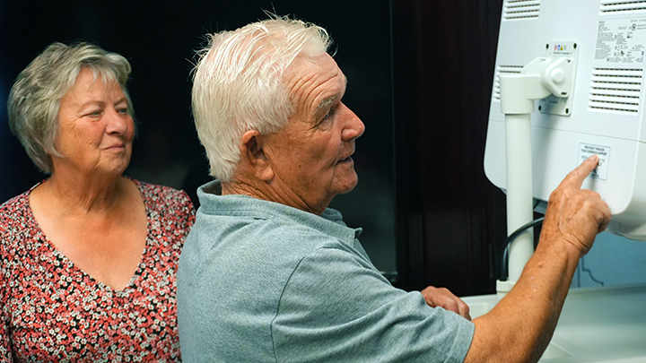 Donors Angie, left, and Clinton Coyne apply a label in recognition of their gift, a Fiberoptic Endoscopic Evaluation of Swallowing (FEES) machine.