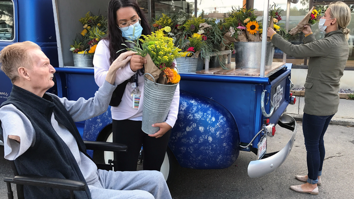  Mackenzie Place resident Darwin Tost gets some assistance from recreation therapist Gina Mariano in choosing a bouquet from Joline Willsey’s Gypsy Blooms Flower Truck in Grande Prairie.