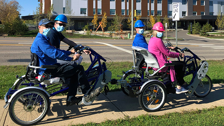 AHS Facilities Maintenance and Engineering staff in Fort McMurray show off how a new custom-built e-bike can accommodate up to four people.
