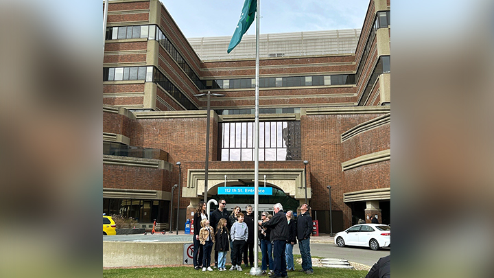 Organ and tissue donor Andy Polanski’s family members raise the new Give Life Alberta flag.