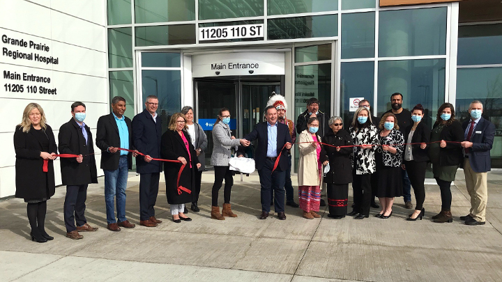 Attendees watch on as new mom Mary Wiebe officially cuts the ribbon for the new hospital.