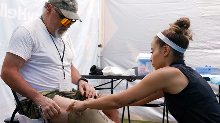 Maylynn Diggs, a member of Edmonton Zone’s Vulnerable Populations team, makes sure that Shawn Bremner’s leg is doing well and that there aren’t any wound-care concerns. These kinds of assessments are a part of the Healthier Together health and wellness fairs hosted weekly by AHS and the City of Edmonton.