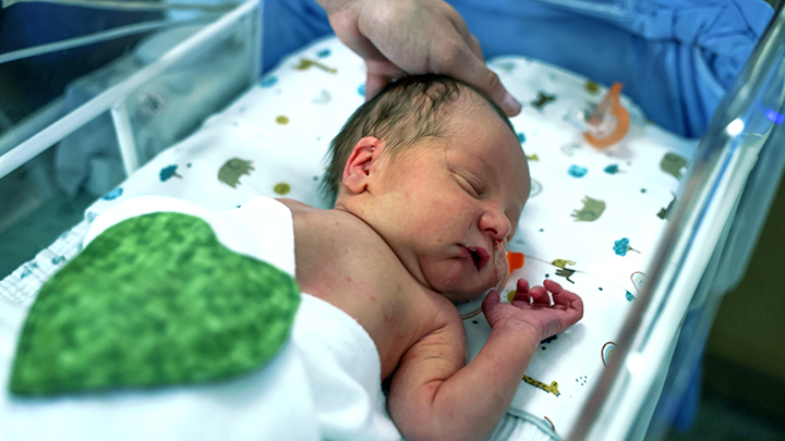 Loveland, son of Darby Ewashina and Micah DeHenau, wears a flannel heart — a bonding cloth created by Heart Scents and volunteers — that helps newborns to thrive through the power of their parents’ scent.
