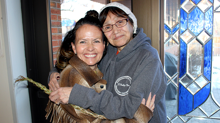 Bea Deak, right, holds a braid of sweetgrass as she embraces Heidi Davis, an AHS recreation therapist, at Harbour House, the YWCA Women’s Shelter in Lethbridge.