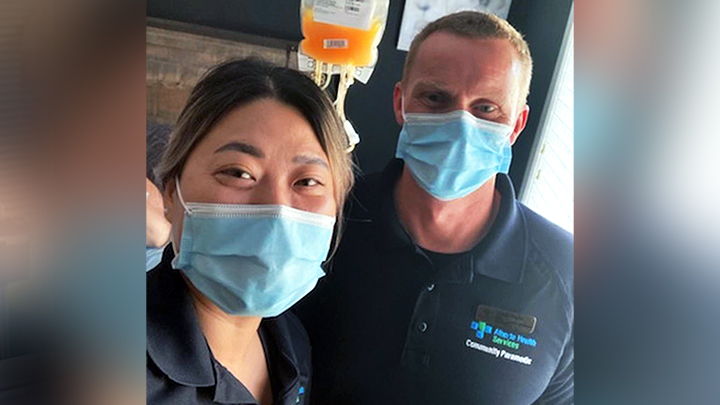 Community Paramedics Hanna Lee, left and Gareth Hughes prepare to provide a platelet transfusion for a cancer patient in their home.