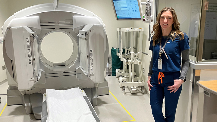 Senior nuclear medicine technologist Kari Monsen stands next to a CT scanner in Grande Prairie Regional Hospital.