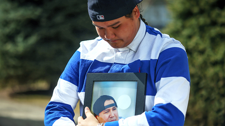 Mason Machiskinic holds a photo of his dad, Fletcher, who passed away from COVID-19.