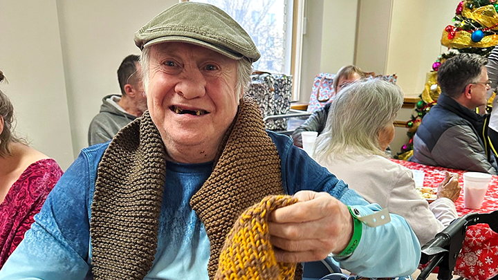 Ian Pye is all smiles after receiving a hand-knit scarf courtesy of Edmonton’s Operation Friendship Seniors Society volunteers. The local charity donated 30 gift bags so all the patients on his unit could feel the spirit of giving this holiday season.