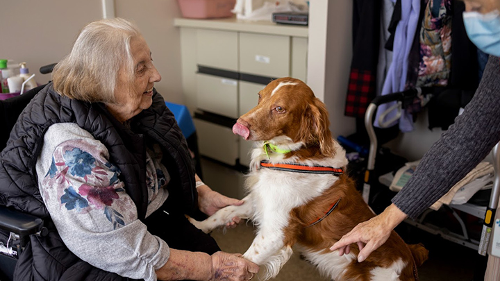 Volunteer Sally Bartman, right, and her pup Beckett bring a ‘pawsitive’ greeting to a patient at Brooks Health Centre.