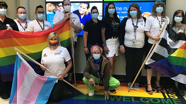 The team at Peter Lougheed Centre stand with PRIDE on their new flooring.