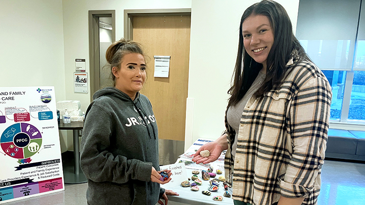 Sarah Stamp, left, shows off her newly painted rock with Occupational Therapy student Lauren Eiriksson.